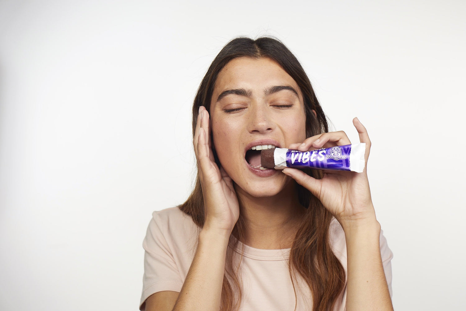 young girl biting a frozen chocolate dessert